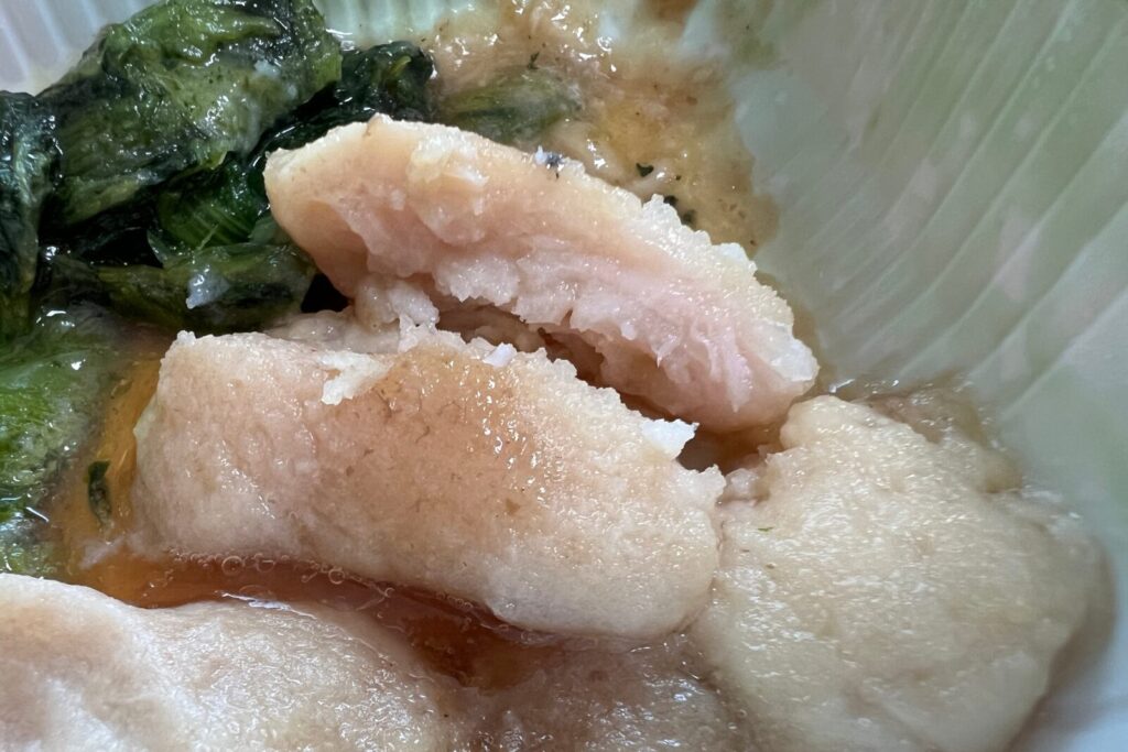 箸でほぐした鶏胸肉の断面と、四角い形が残った小松菜