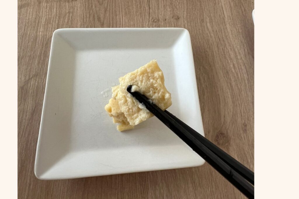 卵焼きのムースを箸で持ったところ。中に細かい気泡が見える